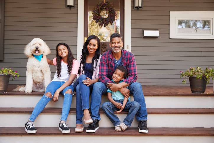 Family With Children And Pet Dog Sit On Steps Of Home praetector